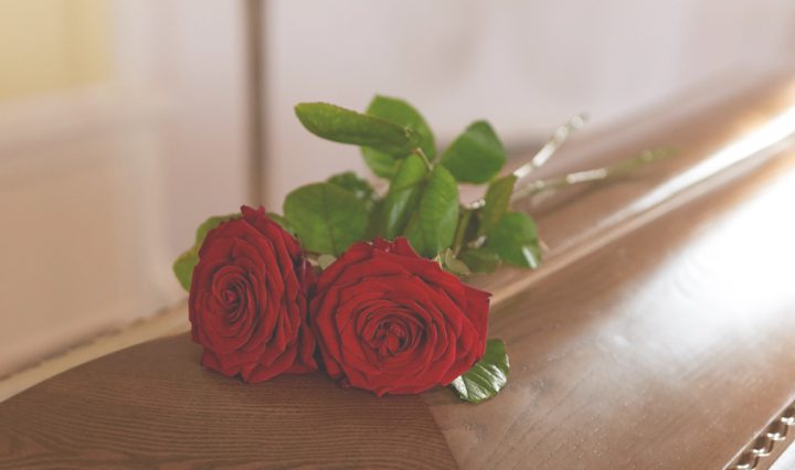 coffin with 2 roses on top - guilt when grieving is common.