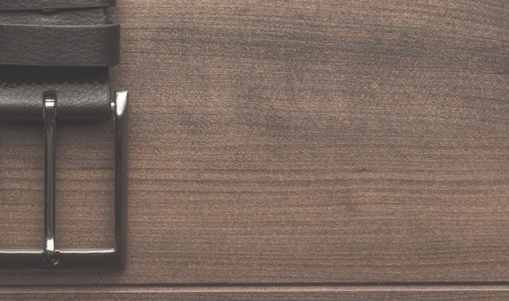 mens belt buckle on brown wood background