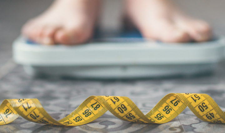 feet on bathroom scales and a measuring tape on the floor