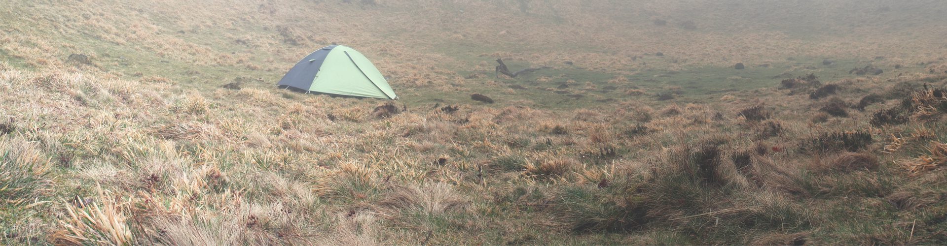 tent on a hill on a misty morning - tips for camping in the rain