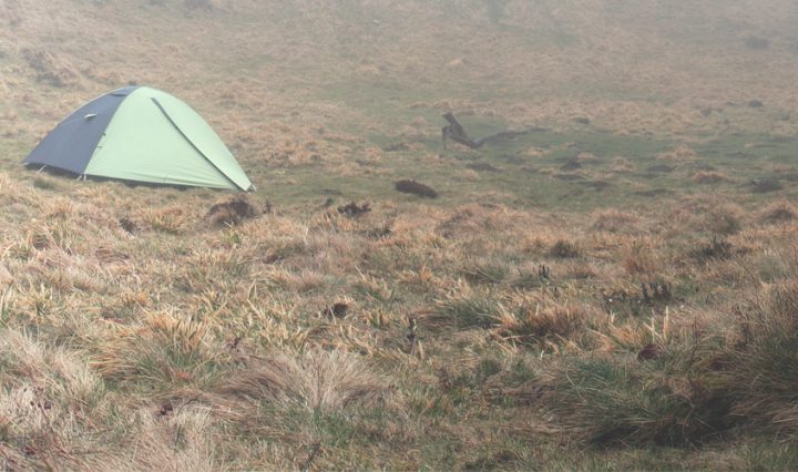 tent on a hill on a misty morning - tips for camping in the rain